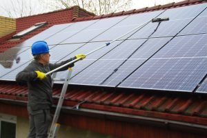Cleaning-solar-panels.-A-man-on-a-ladder-cleans-and-washing-a-photovoltaic-installation.jpg