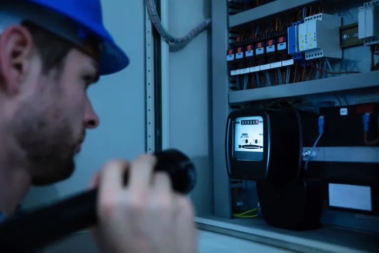Close Up Of A Electrician Examining A Fuse Box With A Torch. Consumer Unit With SPD And RCBOs, Solar Panel Installers UK, Battery Ready Setup.