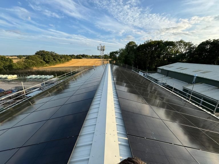 solar-panel-installers-UK.-All-black-solar-panels-on-a-metal-factory-roof.jpg