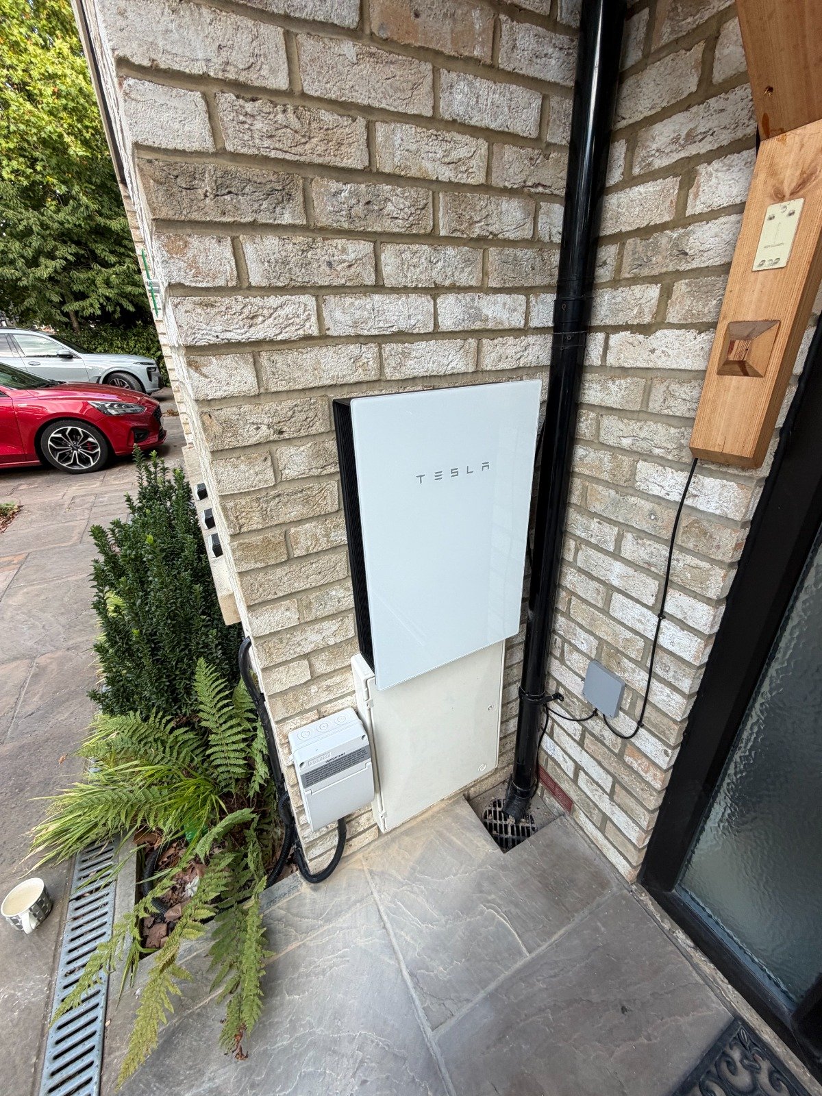 Tesla-Powerwall-home-battery-storage-system-with-Gateway-installed-outside-a-UK-home.jpeg